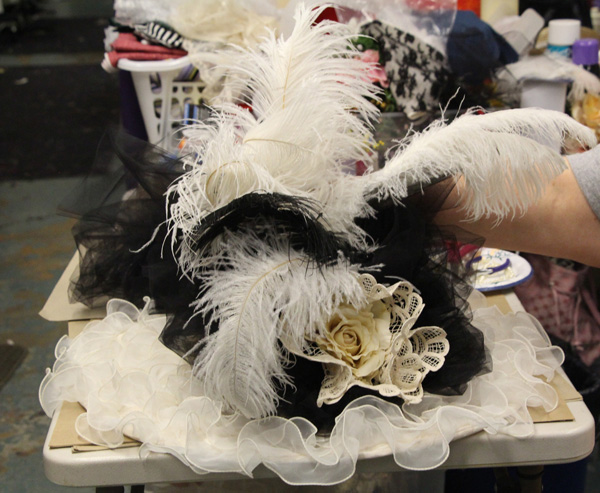Hello, Dolly features many elaborate costumes, include large, fancy, feathered hats.