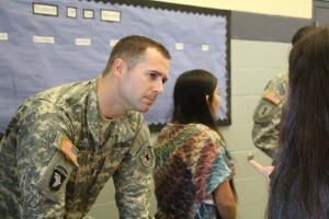 Staff Sgt. Joseph Schaffner listens to a student outside of the cafeteria during lunch. CREDIT: JACOB TAVERA